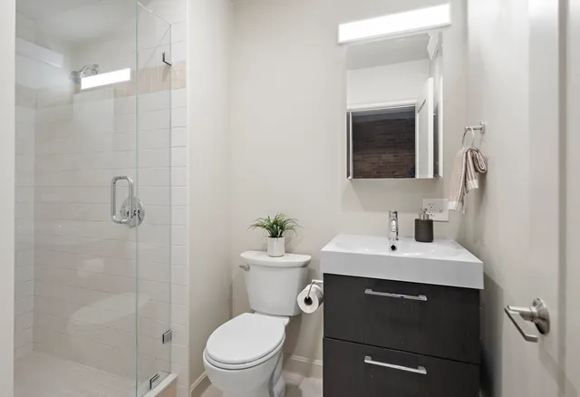 a bathroom with a toilet a sink and mirror