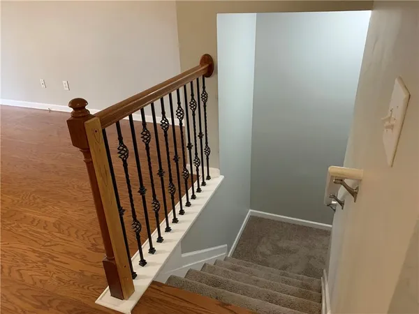 a view of a hallway with wooden floor and staircase