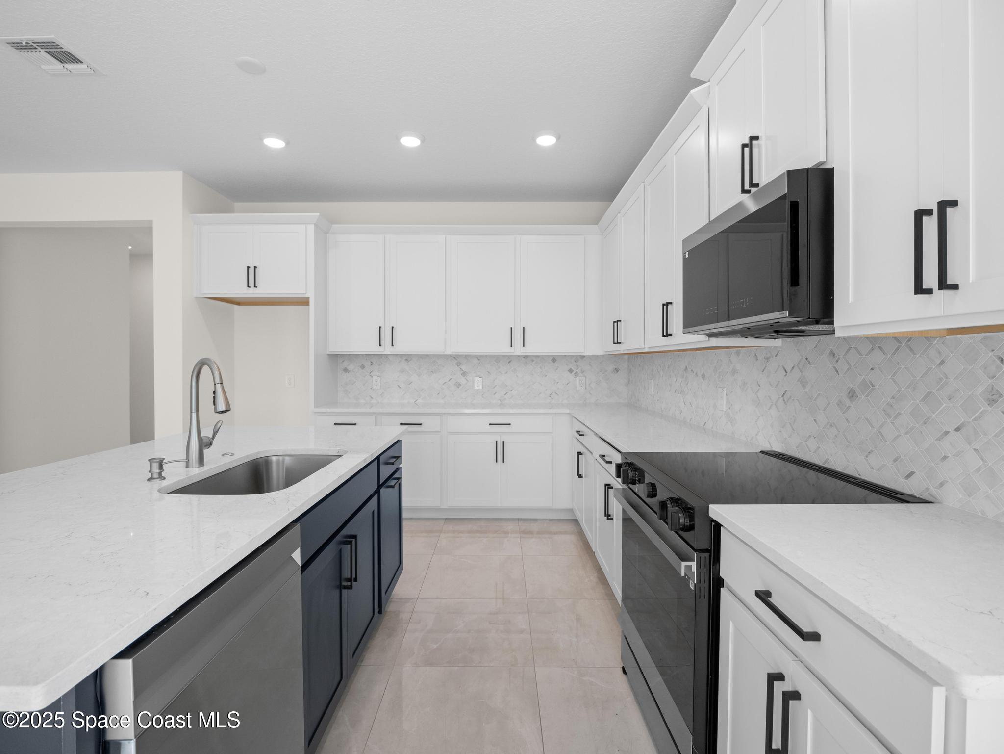 2112 Killian Drive Palm Bay, FL 32905 - Photo 12 of 19 a kitchen that has a sink and a stove in it
