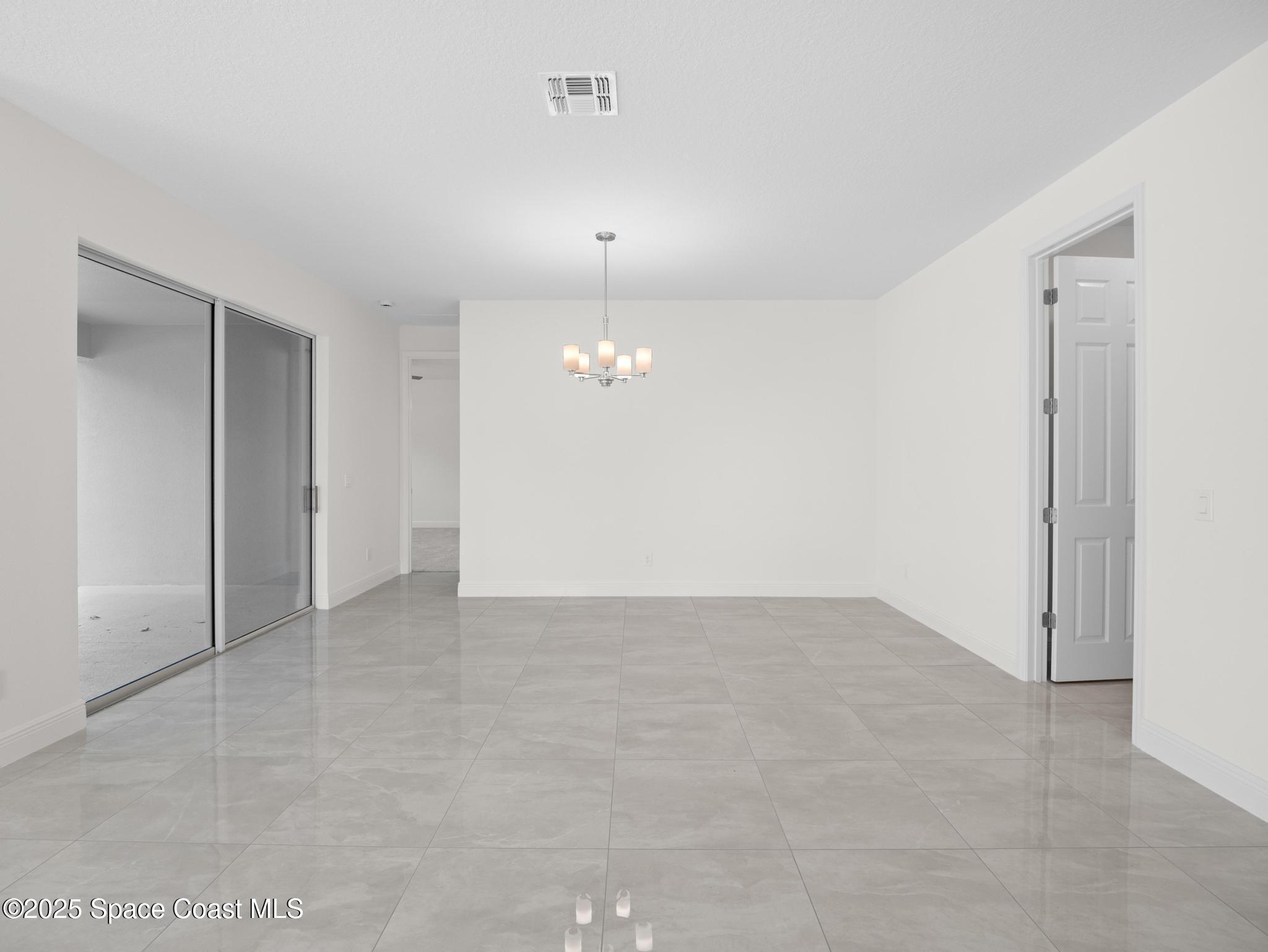 2112 Killian Drive Palm Bay, FL 32905 - Photo 13 of 19 an empty room with chandelier fan and refrigerator