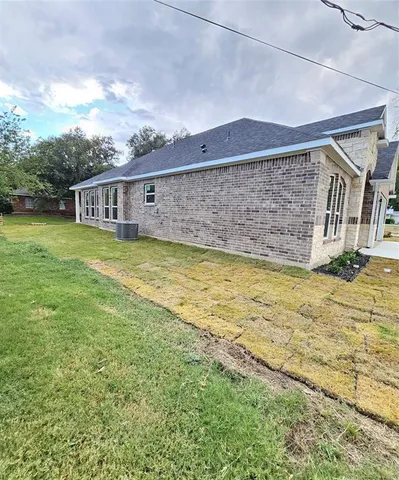 a front view of house with yard and trees around