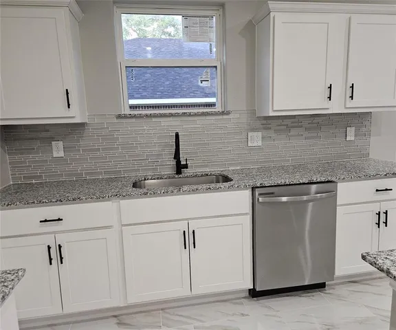 a kitchen with stainless steel appliances granite countertop white cabinets sink and dishwasher