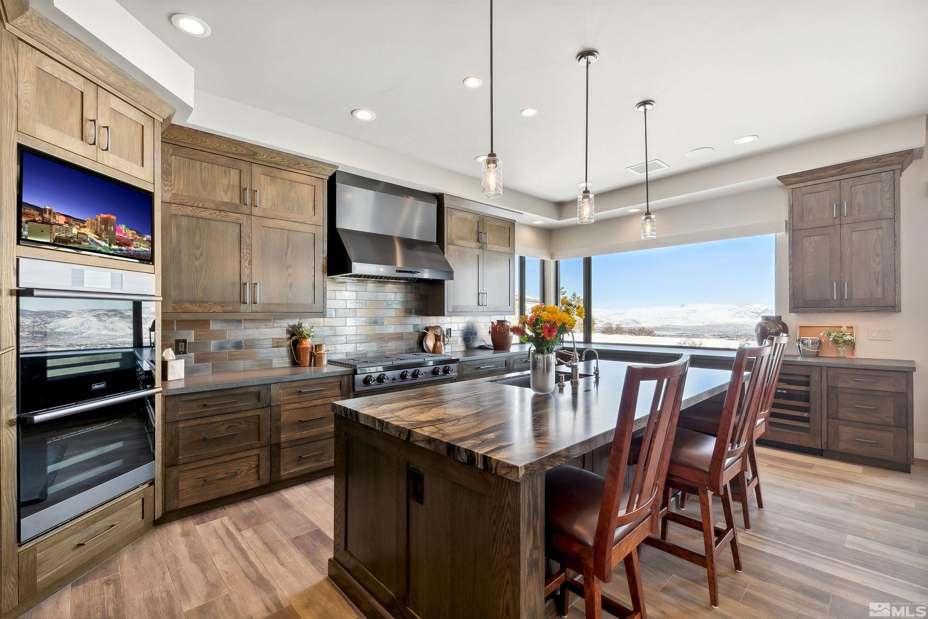 4110 Spotted Eagle Court Reno, NV 89511 - Photo 10 of 40 a kitchen with stainless steel appliances granite countertop a stove a sink dishwasher a refrigerator with a dining table and chairs