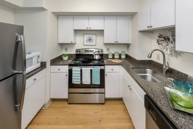 a bathroom with a granite countertop sink mirror and toilet