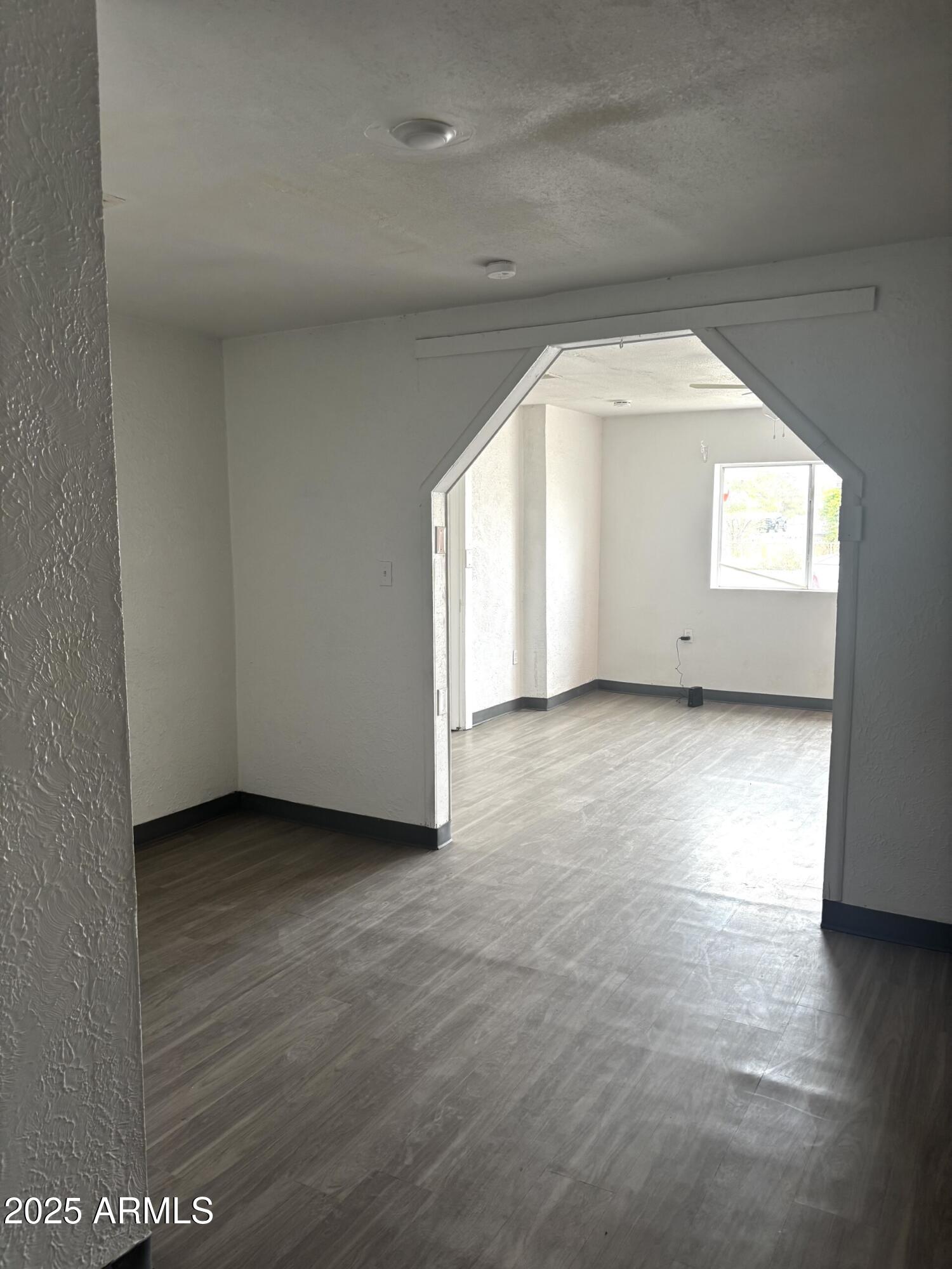 398 E Avenue Douglas, AZ 85607 - Photo 4 of 11 an empty room with wooden floor and windows