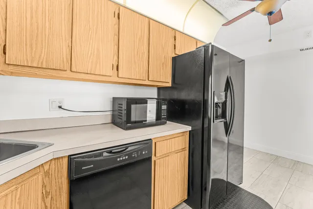 a kitchen with stainless steel appliances granite countertop a refrigerator a sink and dishwasher