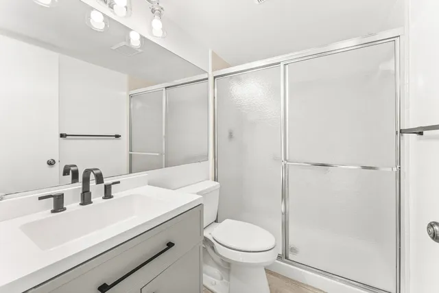 a bathroom with a sink a toilet and shower