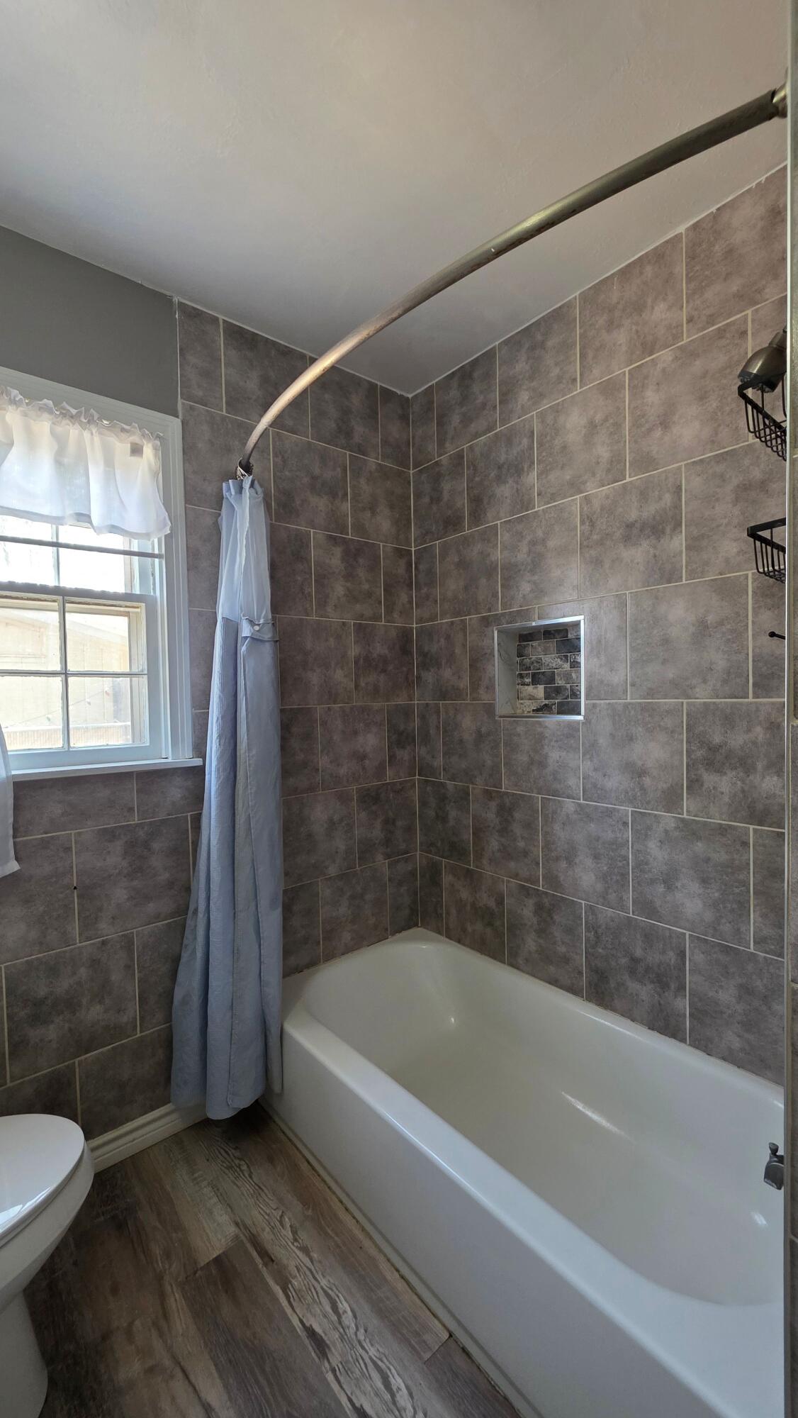 2403 38th Street Lubbock, TX 79412 - Photo 11 of 17 a bathroom with a sink a toilet and a bathtub