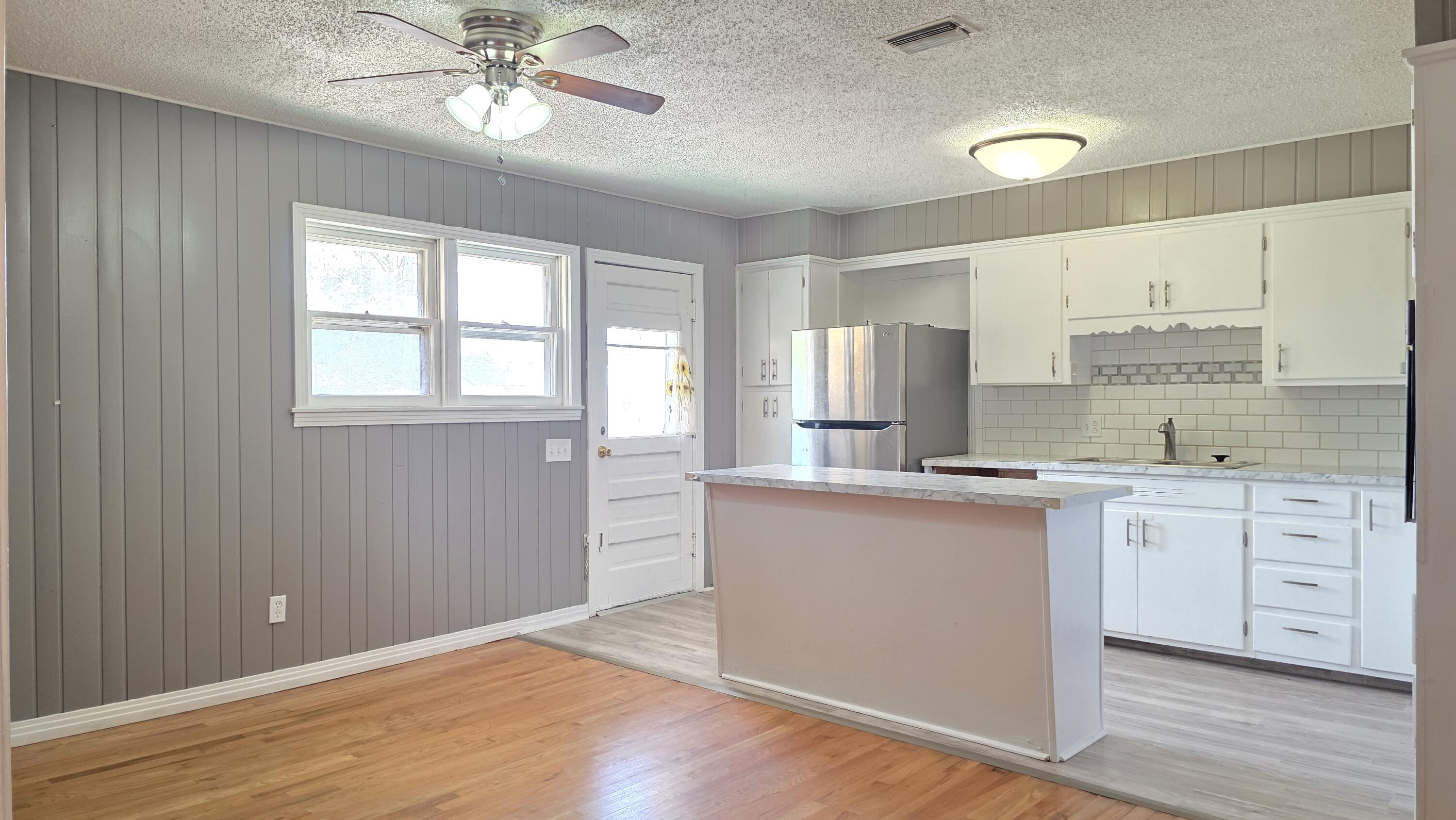 2403 38th Street Lubbock, TX 79412 - Photo 4 of 17 a kitchen with granite countertop white cabinets and white appliances