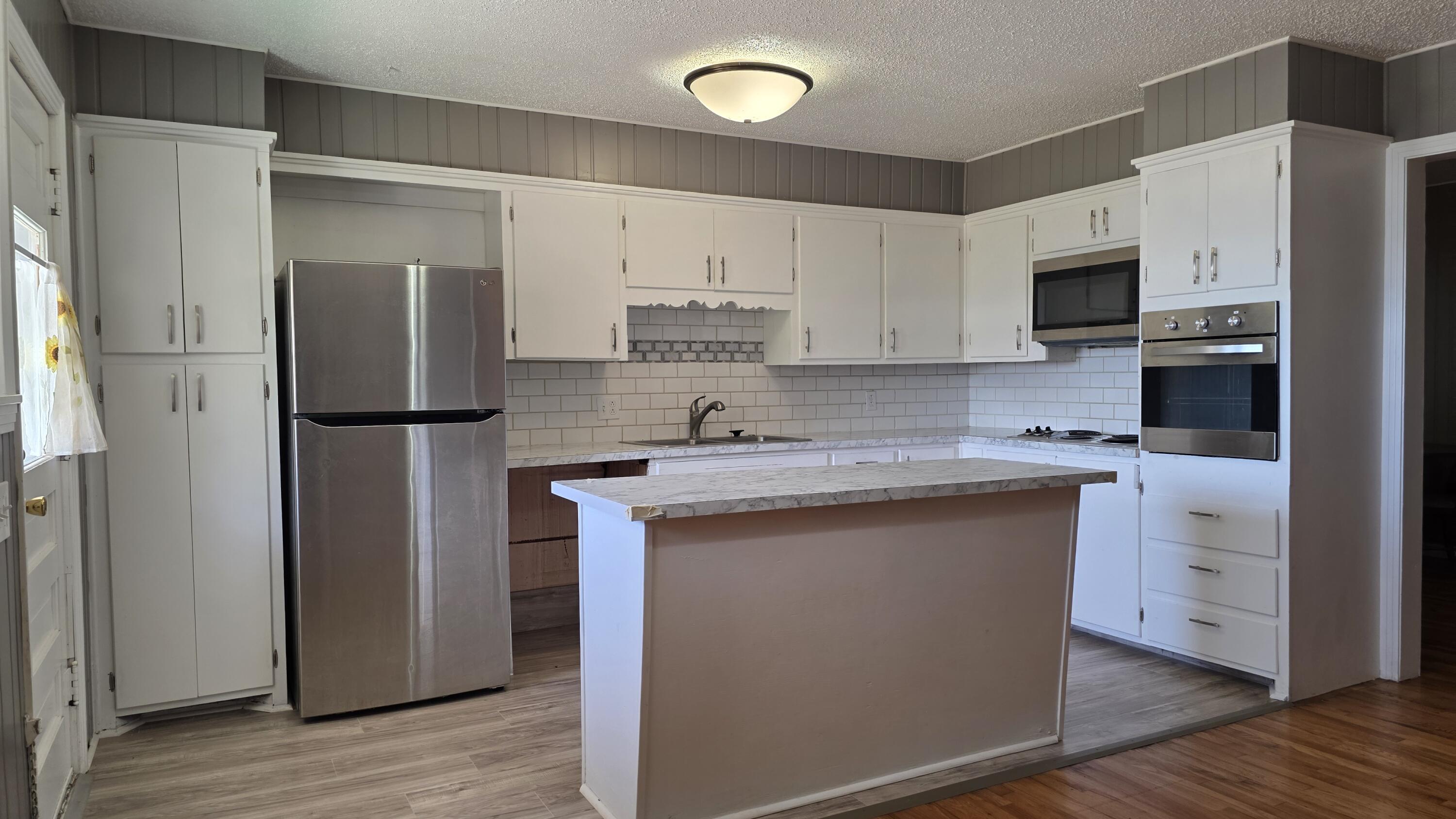 2403 38th Street Lubbock, TX 79412 - Photo 5 of 17 a kitchen with stainless steel appliances granite countertop a refrigerator a stove and a sink