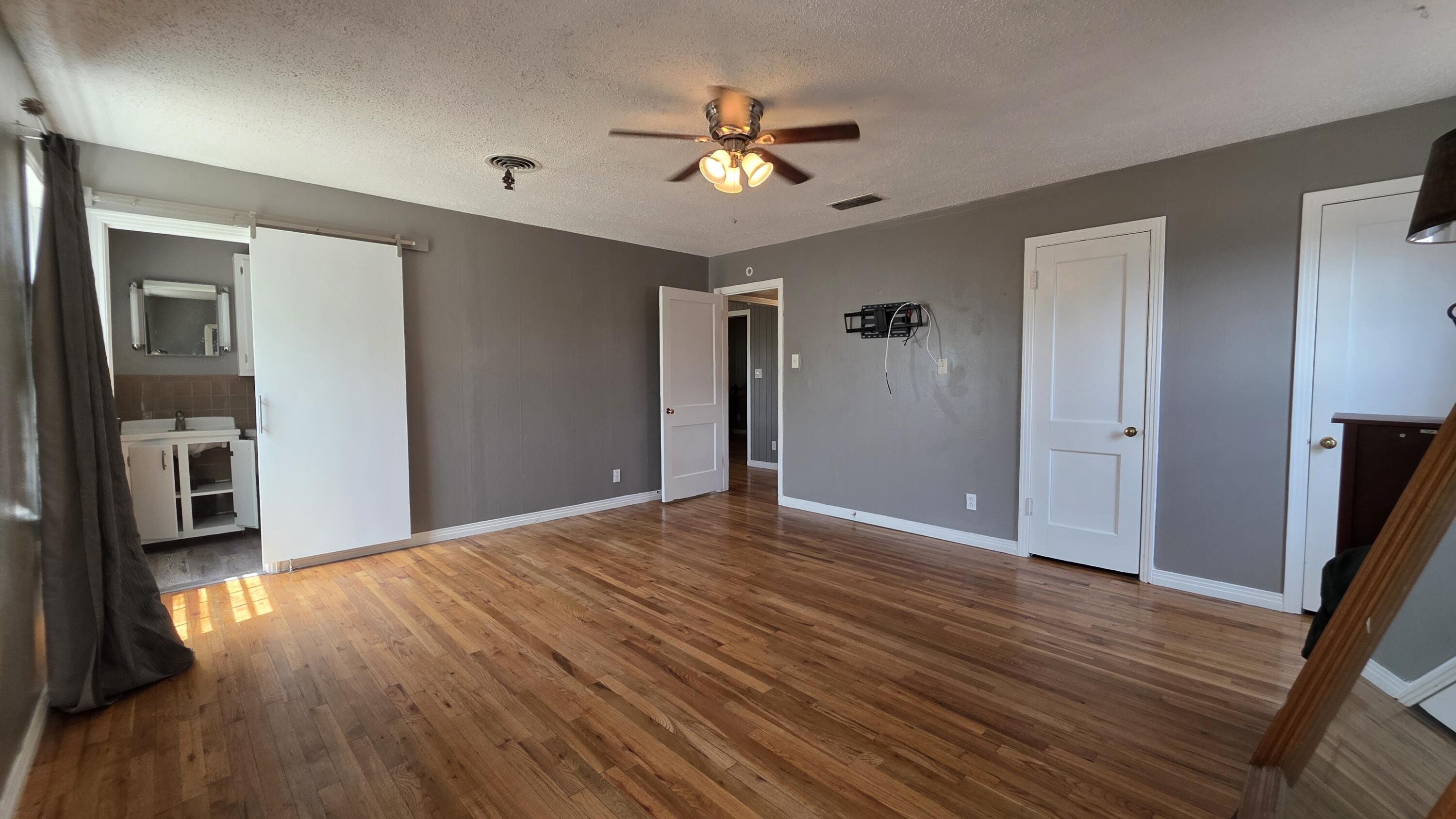 2403 38th Street Lubbock, TX 79412 - Photo 8 of 17 a view of a livingroom with a ceiling fan wooden floor and a ceiling fan