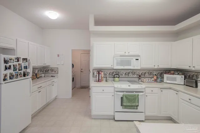 a kitchen with white cabinets appliances and sink
