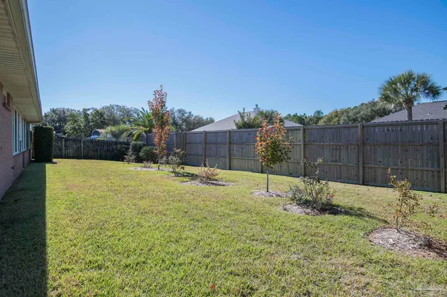 a backyard with a table and chair and wooden fence