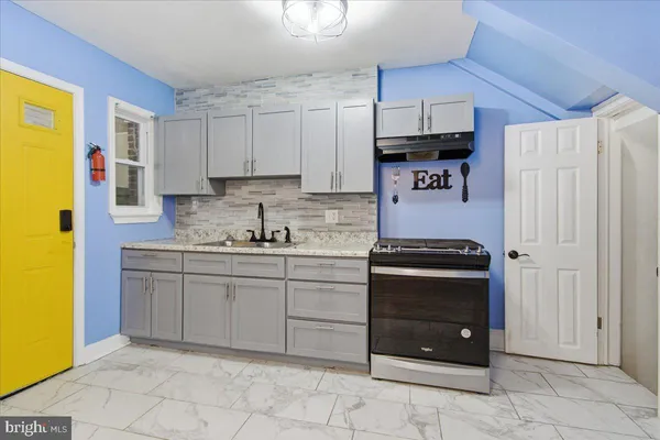 a kitchen with stainless steel appliances granite countertop a refrigerator and a stove top oven