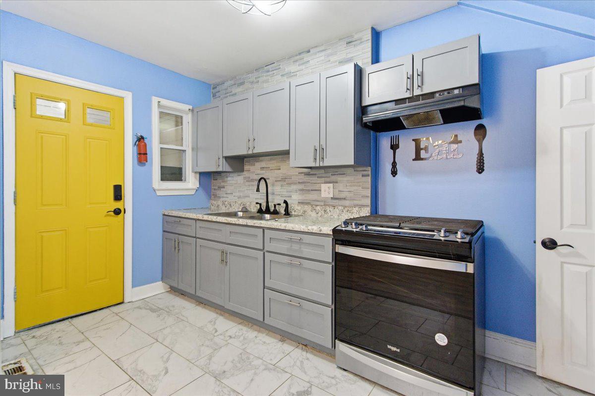 206 36th Street Southeast Washington, DC 20019 - Photo 12 of 28 a kitchen with stainless steel appliances granite countertop a stove a sink and a refrigerator