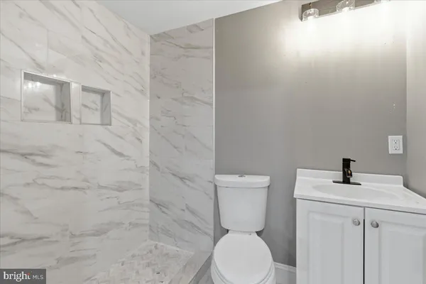 a white toilet sitting next to a shower