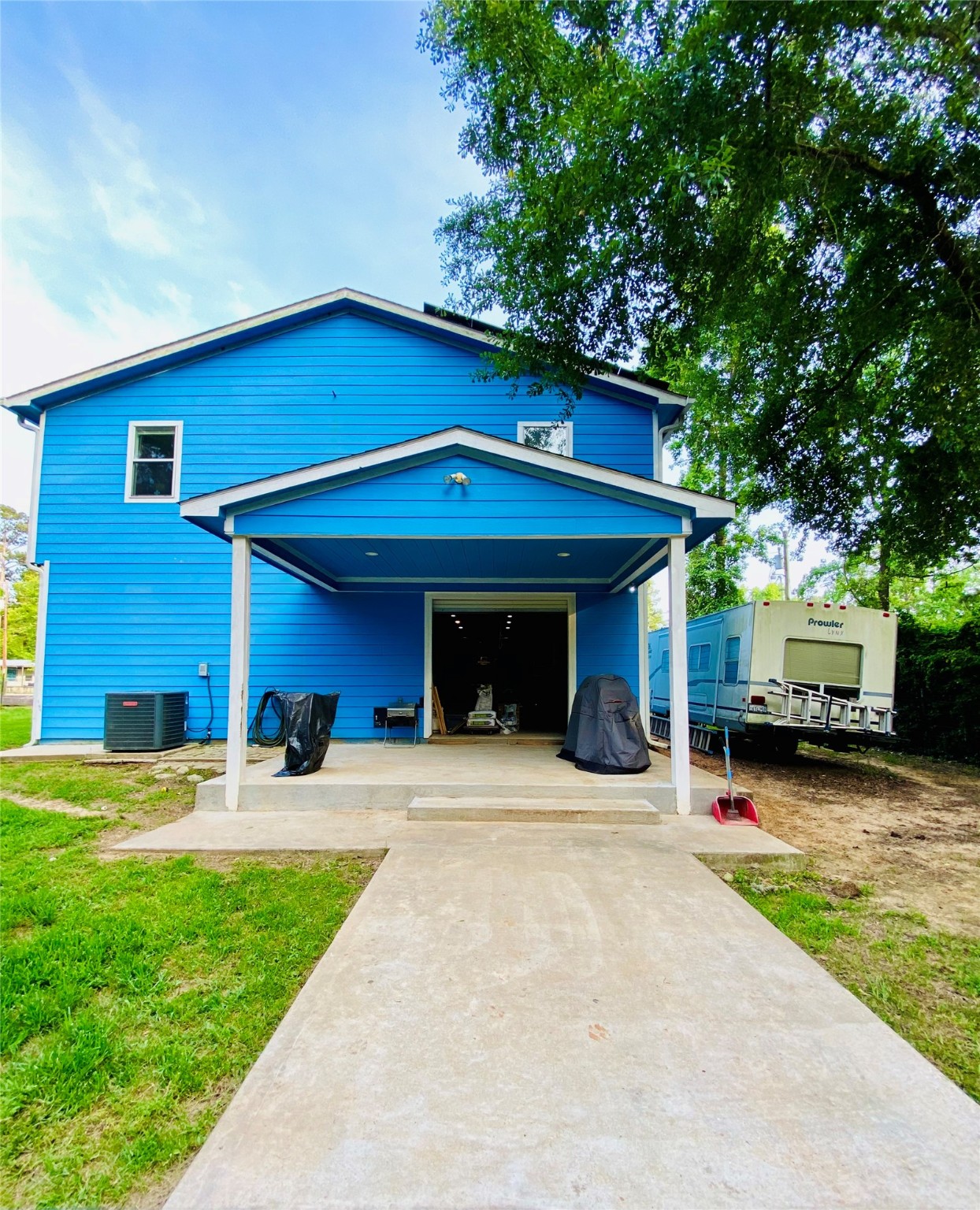 195 Rim Rock Road Onalaska, TX 77360 - Photo 41 of 45 a view of a house with potted plants and a large tree