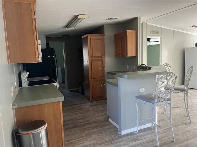 a kitchen with a sink cabinets and wooden floor
