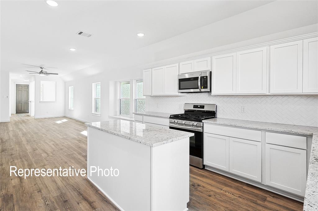 2709 Baker Farm Road Forney, TX 75126 - Photo 4 of 10 Kitchen featuring a center island, white cabinetry, stainless steel range, and built-in microwave