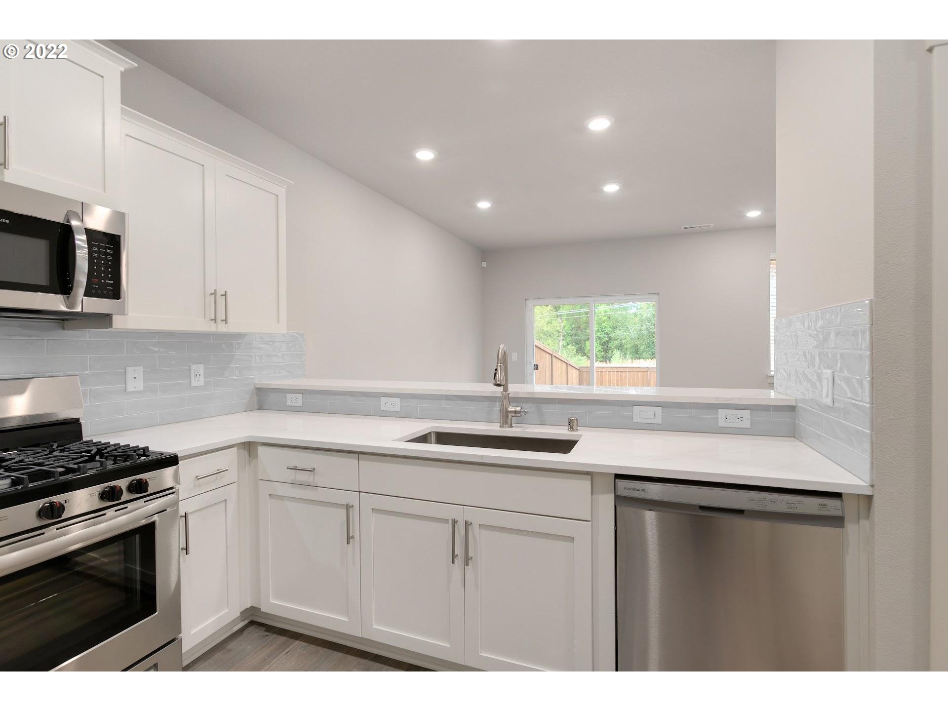 2413 South Brookside Place Ridgefield, WA 98642 - Photo 9 of 22 a kitchen with a sink stove and microwave
