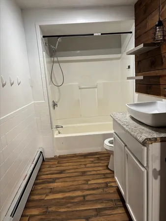 a bathroom with a granite countertop sink a toilet and shower