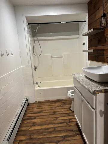 a bathroom with a granite countertop sink a toilet and shower