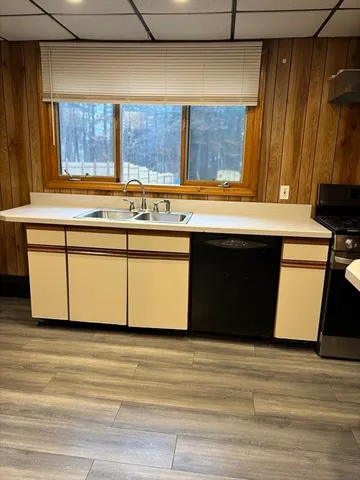 a kitchen with a sink cabinets and a wooden floor