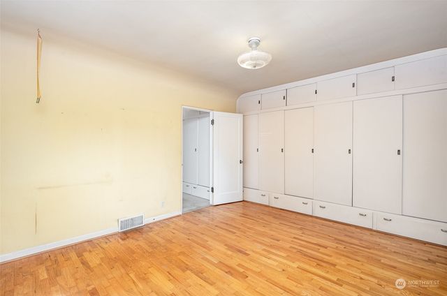 a view of empty room with window and hardwood floor