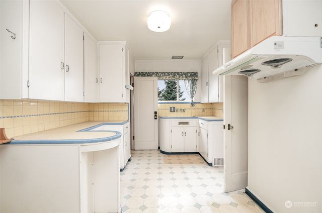 a kitchen with a sink cabinets and wooden floor