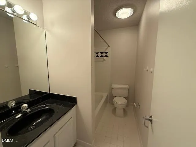 a bathroom with a granite countertop sink and a toilet