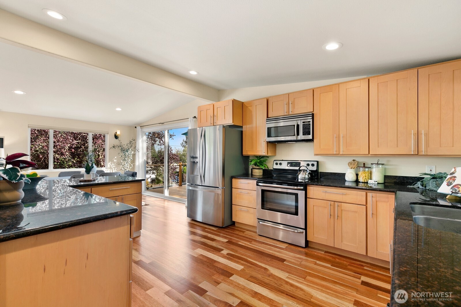 3701 Southwest Southern Street Seattle, WA 98126 - Photo 8 of 33 a kitchen with stainless steel appliances granite countertop a stove top oven a sink dishwasher a refrigerator and cabinets with wooden floor
