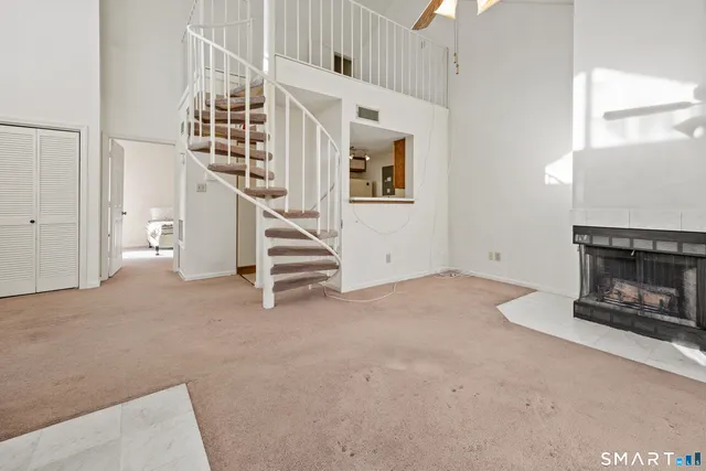 a view of an empty room with window and chandelier fan