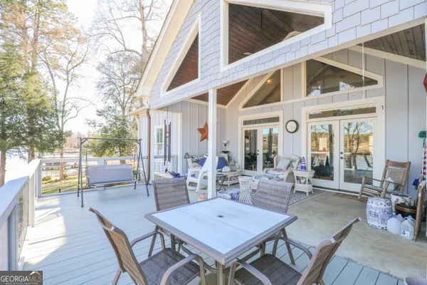a view of a patio with couches table and chairs and wooden floor