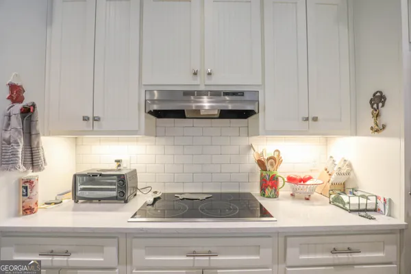 a kitchen with white cabinets and black appliances