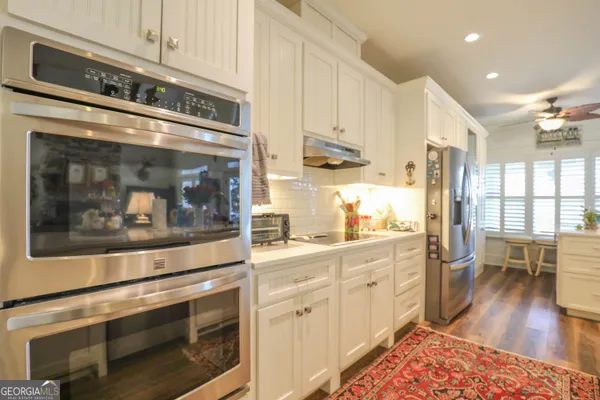 a kitchen with stainless steel appliances granite countertop a stove and white cabinets