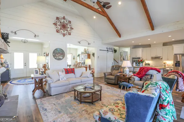 a living room with lots of furniture and view of kitchen