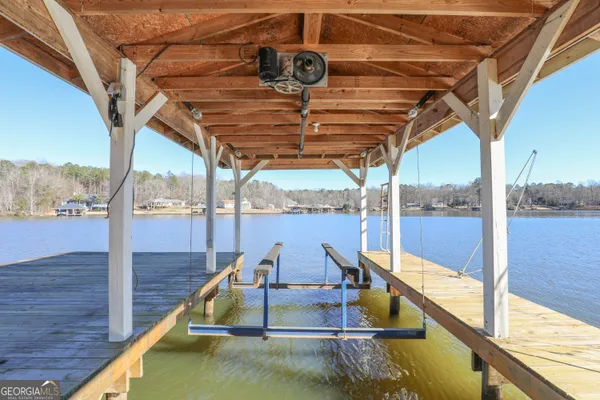 a view of a wooden house with a large window and potted plants