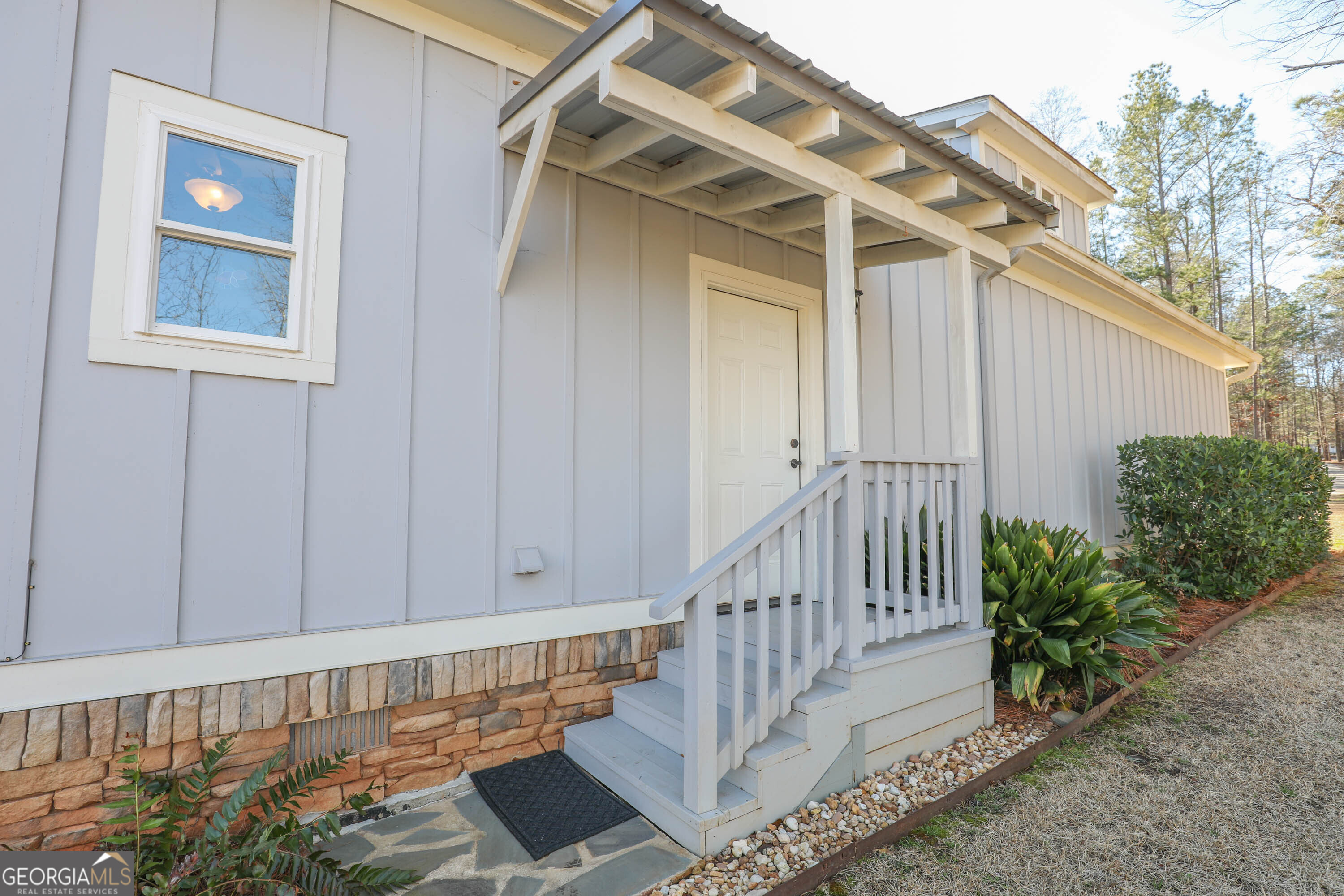 124 Myrick Road Northwest Milledgeville, GA 31061 - Photo 35 of 41 a view of a wooden house with a large window and potted plants