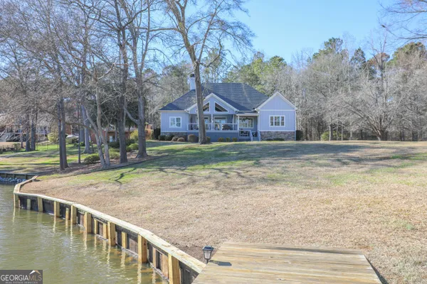 a view of a house with a yard and large trees