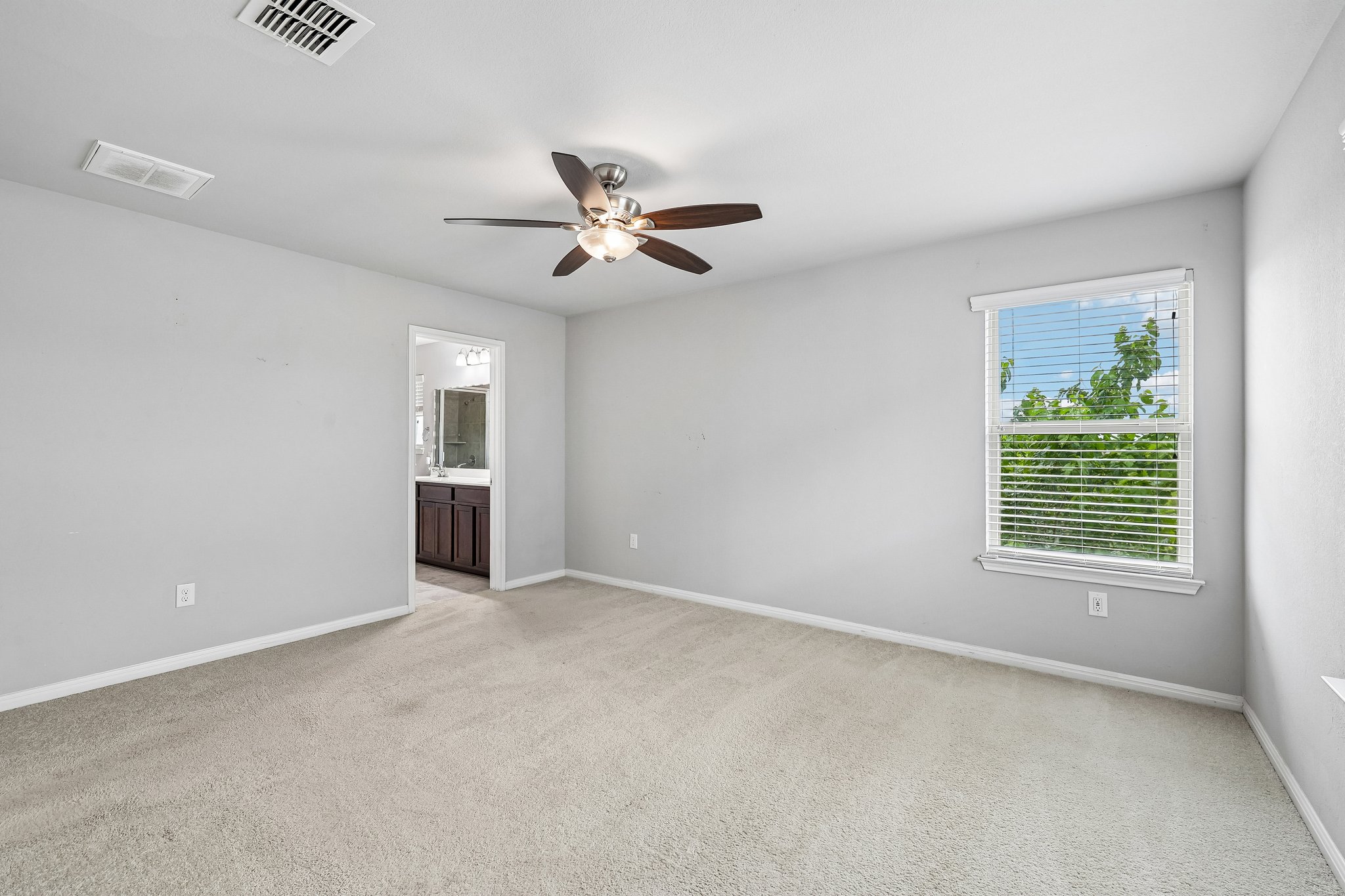387 Guemal Road Buda, TX 78610 - Photo 28 of 39 Carpeted room with light gray walls, a ceiling fan with integrated lighting, and a single window with blinds