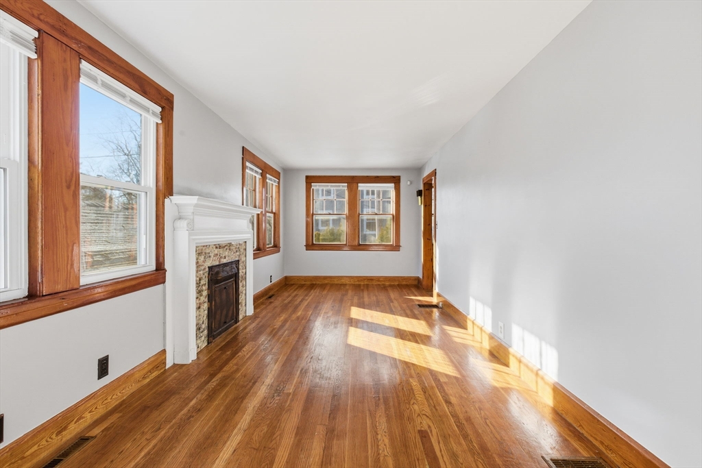 8 Plain Street Randolph, MA 02368 - Photo 11 of 38 a view of an empty room with a fireplace and a window