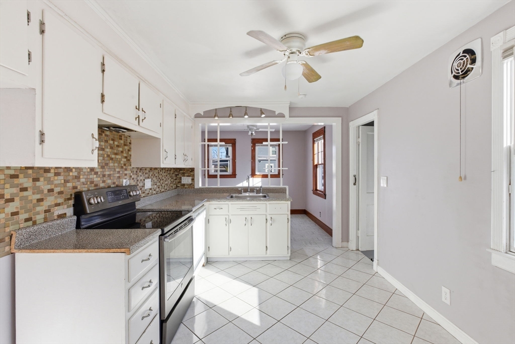 8 Plain Street Randolph, MA 02368 - Photo 13 of 38 a kitchen with stainless steel appliances granite countertop a stove cabinets and a refrigerator
