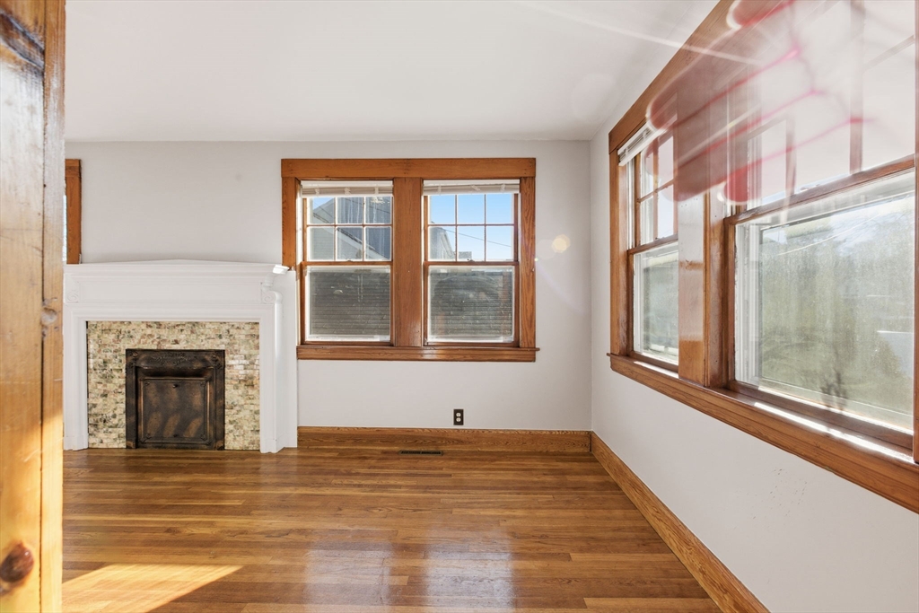 8 Plain Street Randolph, MA 02368 - Photo 7 of 38 a view of an empty room with a fireplace and a window