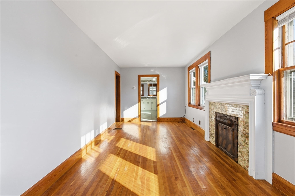 8 Plain Street Randolph, MA 02368 - Photo 9 of 38 a view of a livingroom with wooden floor and a fireplace