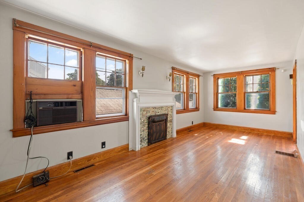 8 Plain Street Randolph, MA 02368 - Photo 9 of 25 a view of empty room with a fireplace and wooden floor