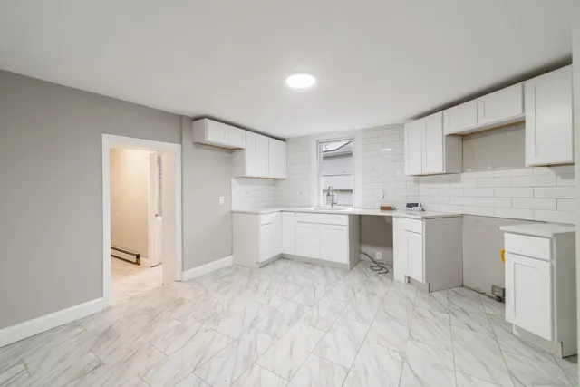 a kitchen with white cabinets and white appliances