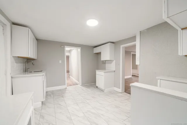 a large white kitchen with a sink a stove and a refrigerator
