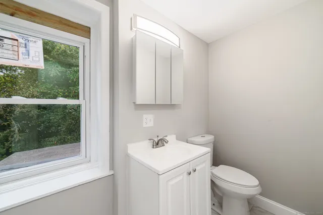 a bathroom with a toilet a sink and a window
