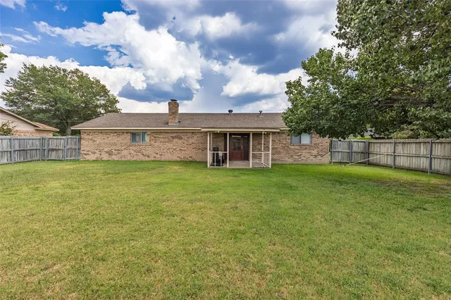 a view of a house with a big yard and large tree