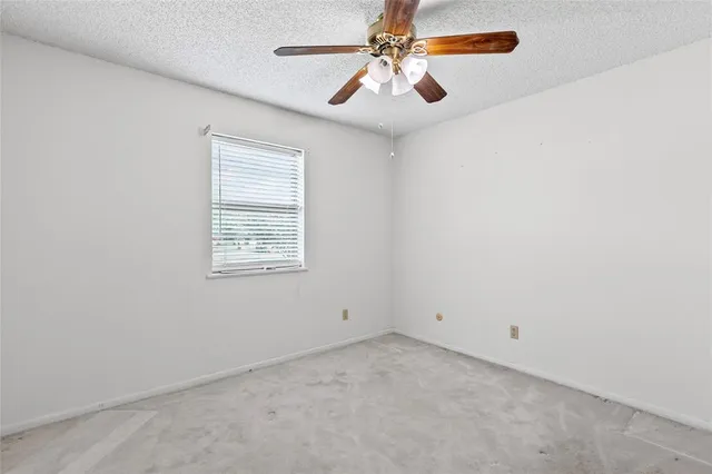 an empty room with chandelier fan